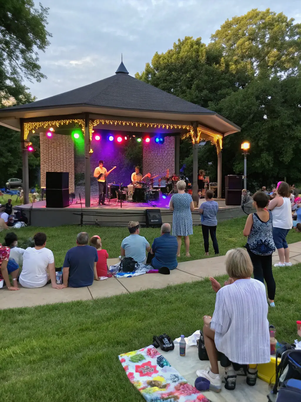 A diverse audience enjoying an outdoor cultural event organized by ASS CARRE MAGIQUE, highlighting the organization's role in community engagement.